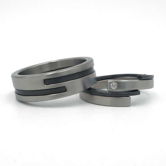 “Set moderne Adam-Eva ringen van titanium en zwart zirkonium met diamant 0.015ct”