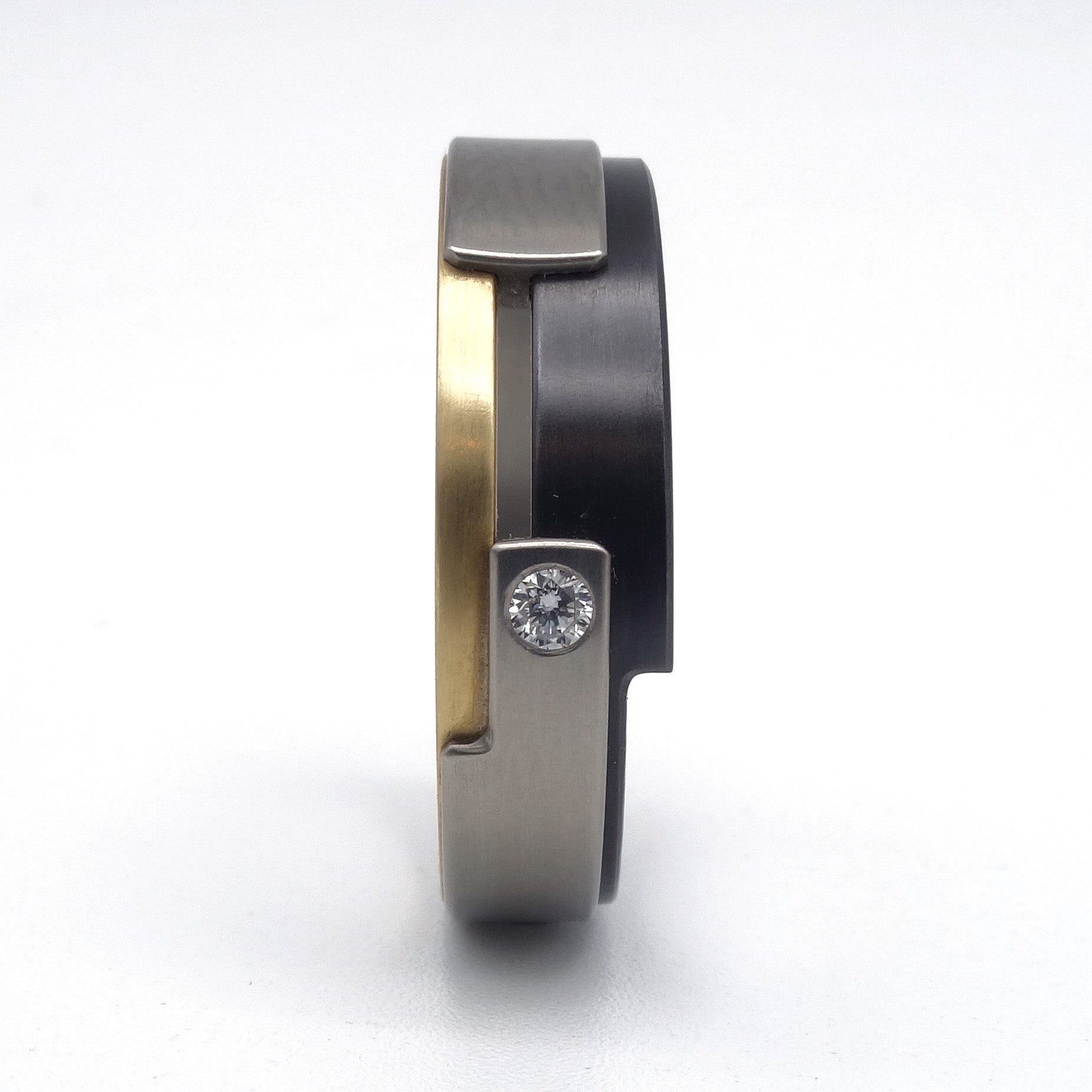 Aquila Smal-ring van geelgoud, titanium en zirkonium met diamant – verfijnd, modern ontwerp met subtiel fonkelend detail.

