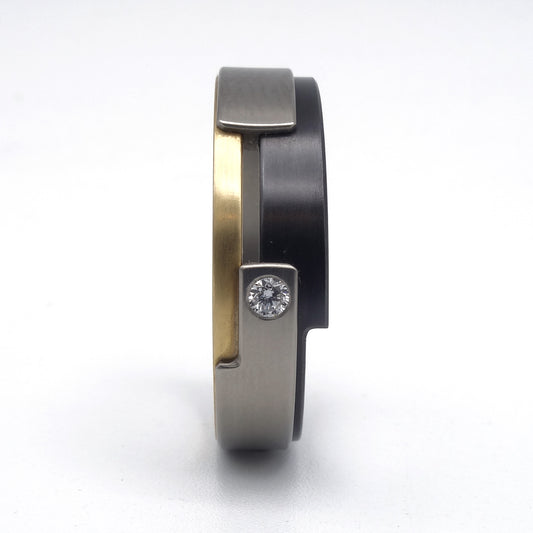 Aquila Smal-ring van geelgoud, titanium en zirkonium met diamant – verfijnd, modern ontwerp met subtiel fonkelend detail.

