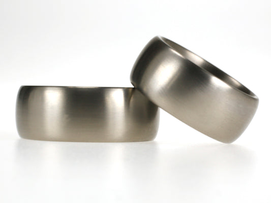 Brede titanium trouwringen van 9 mm met bol profiel en matte afwerking.