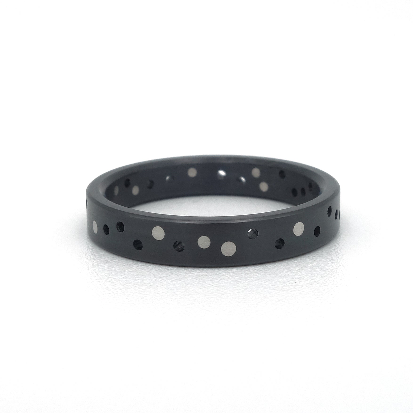 Zwarte zirkonium ring Confetti Black met willekeurig patroon van platina stippen.