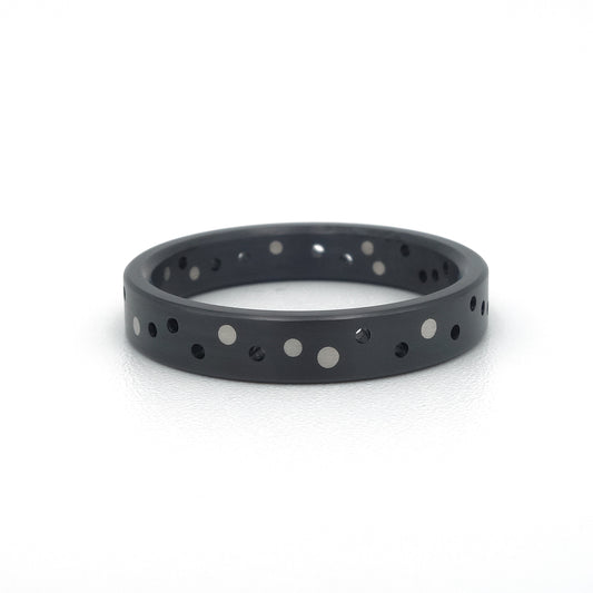 Zwarte zirkonium ring Confetti Black met willekeurig patroon van platina stippen.