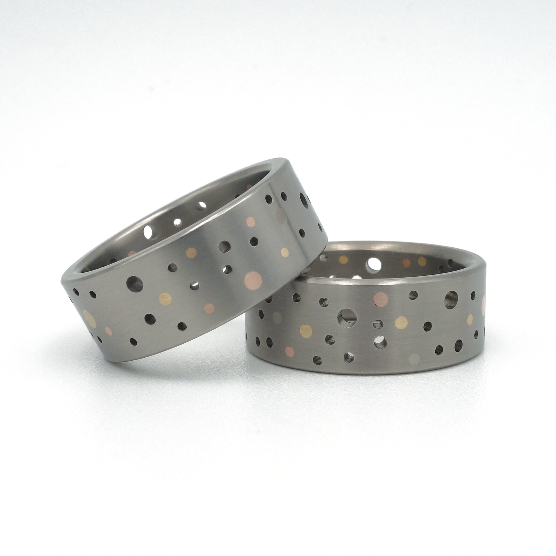 Set titanium Confetti-ringen met gouden en platina stippen in willekeurig gatenpatroon.