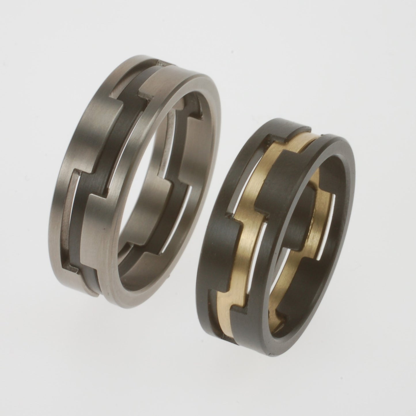 Set trouwringen met open structuur in zirkonium, geelgoud en titanium in grafisch patroon

