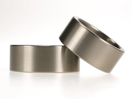 Brede titanium trouwringen van 9 mm met rechte vorm en matte afwerking.
