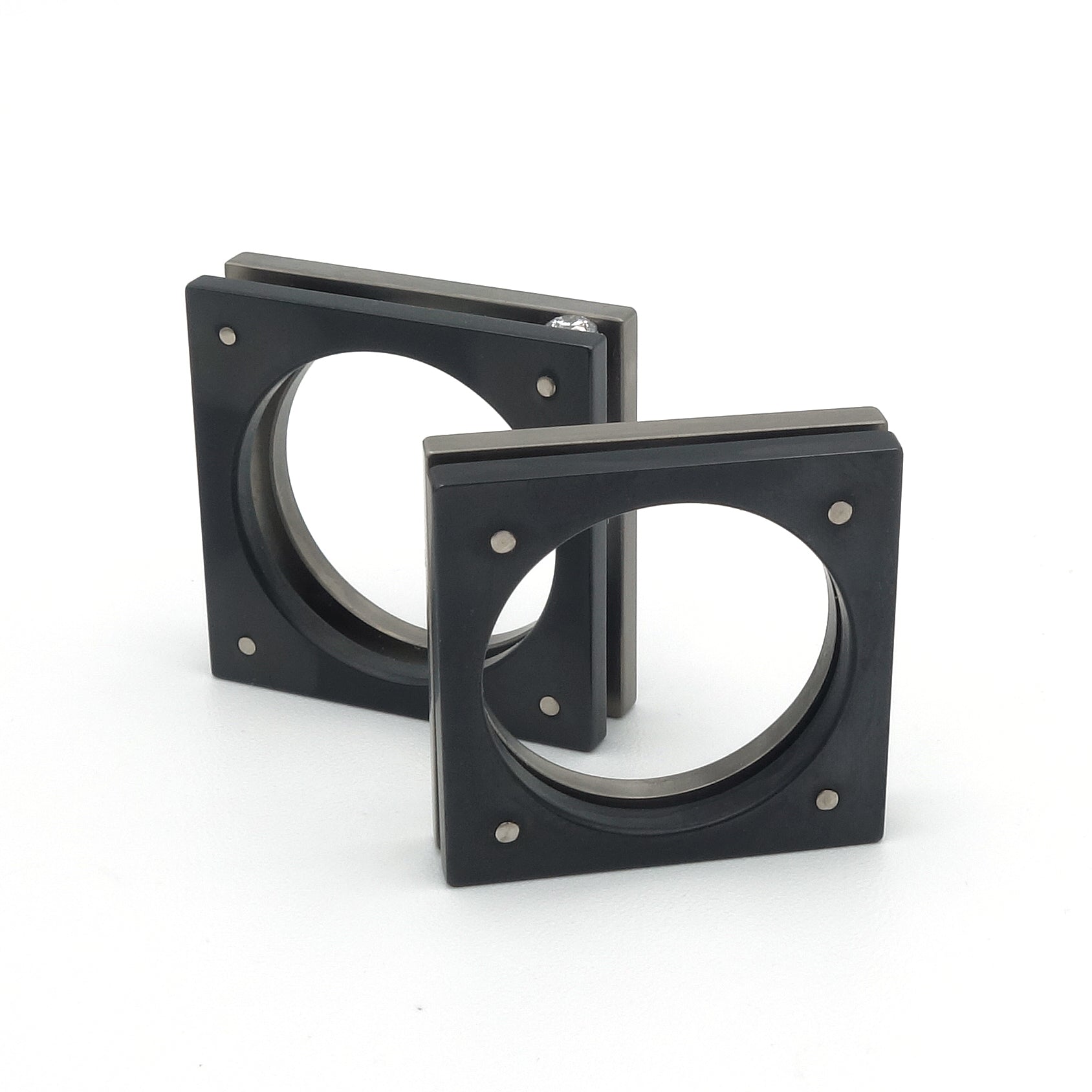 Vierkante ring in grijs titanium en zwart zirkonium. Beide delen staan iets van elkaar af en zijn gelijk in vorm.