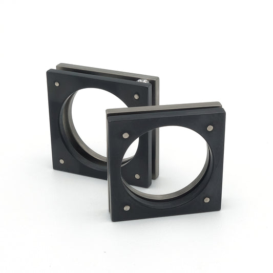 Vierkante ring in grijs titanium en zwart zirkonium. Beide delen staan iets van elkaar af en zijn gelijk in vorm.