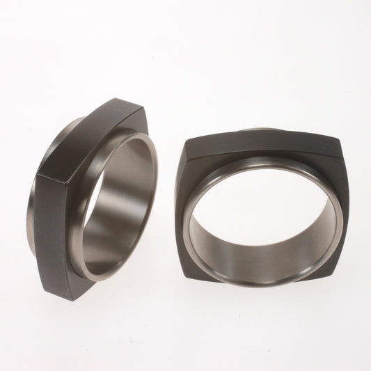 Vierkante zwarte zirkoniumring met ronde titanium binnenring die iets uitsteekt
