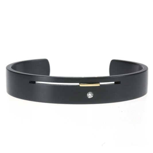 Split-Level armband van zwart zirkonium met geelgouden accent en diamant – moderne, open armband met strak lijnenspel.

